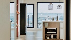 Une cuisine moderne avec vue sur la ville, un plancher en bois et un coin repas avec une chaise.
