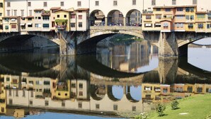 A stone bridge over a calm river with buildings reflecting on the water. - Beautiful apartment for 5 guests with A/C, WIFI and TV (Florence)