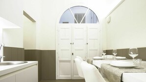 A modern kitchen with white cabinets, a sink, and a dining area with a table set for two. - Beautiful apartment for 5 guests with A/C, WIFI and TV (Florence)