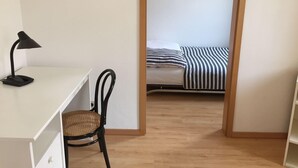 A room with a desk, chair, and a bed with striped bedding. - Kleine Mietidee (Markranstaedt)
