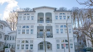 Um edifício com vários andares, varandas e janelas em arco, identificado como "Villa Eden".