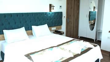 A bedroom with a large bed, a wooden headboard, a wardrobe, and a mirror.