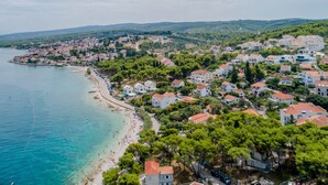 A coastal town with a beach, houses, and a hilly backdrop. - Luxury Villa Complex Pax & Vitae With Heated Infinity Pools, 16 Sleeps (Sutivan)