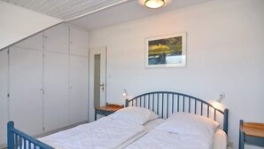 Ein Schlafzimmer mit einem Bett, einem Kleiderschrank und einem Bild an der Wand.