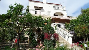 A two-story building with a white facade, a red-tiled roof, and a balcony with white balustrades. - Apartment Vlahov (Barilovic)