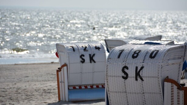 Beach chairs with 'SK' and '180' marked on them, facing the ocean. - Strandglück (Dahme)