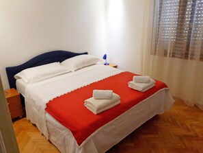 Restful retreat with a neatly made bed, featuring a comfortable bedspread and plush pillows.