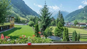 A view from a balcony overlooking a mountainous landscape with a clear sky. - Hotel Sonnhof (Rauris)