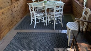 L’intérieur d’un chalet en bois comprend une table et des chaises, de grandes fenêtres et un plafond en bois.