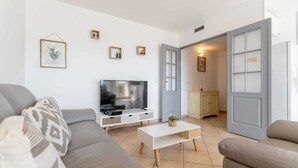 A living room with a TV, sofas, a coffee table, and a cabinet.