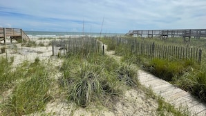 Ein Strand mit Holzstegen und einem Sandweg.