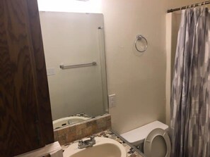 A bathroom with a bathtub, toilet, and sink.
