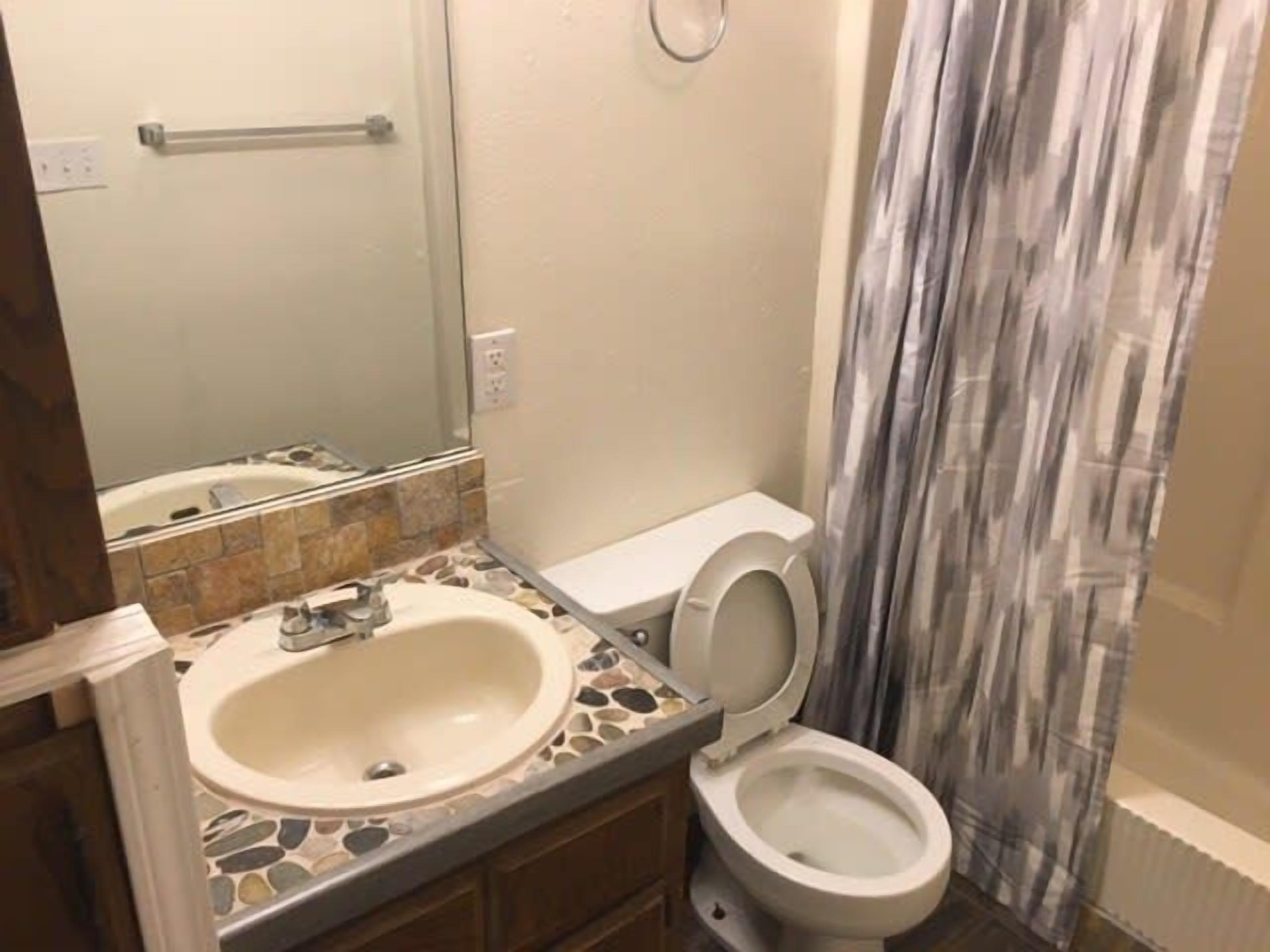 A bathroom with a sink, toilet, and bathtub.