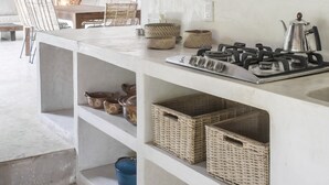 A kitchen with a gas stove, wicker baskets, and a hanging light fixture. - Boutique Resort in Mayan Jungle, Solferino, Quintana Roo (Solferino)