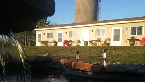 A water feature with a fountain, a pond, and a building with multiple windows and outdoor furniture in the background. - Monthly deals ,  #4  at Beach Mirage Suites  (Brook Park)