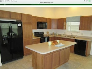 Enjoy cooking in this well-equipped kitchen with a central island and modern cabinetry.