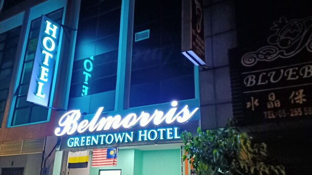 The exterior of the Belmorris Green Town Hotel with a prominent neon sign and Malaysian flag. - Belmorris Greentown Hotel (Ipoh)