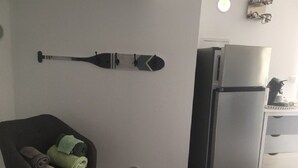 A modern kitchen with a built-in refrigerator and a dining area with a chair and towels. - INDEPENDENT ROOM IN RESIDENCE PORTO VECCHIO (Porto-Vecchio)