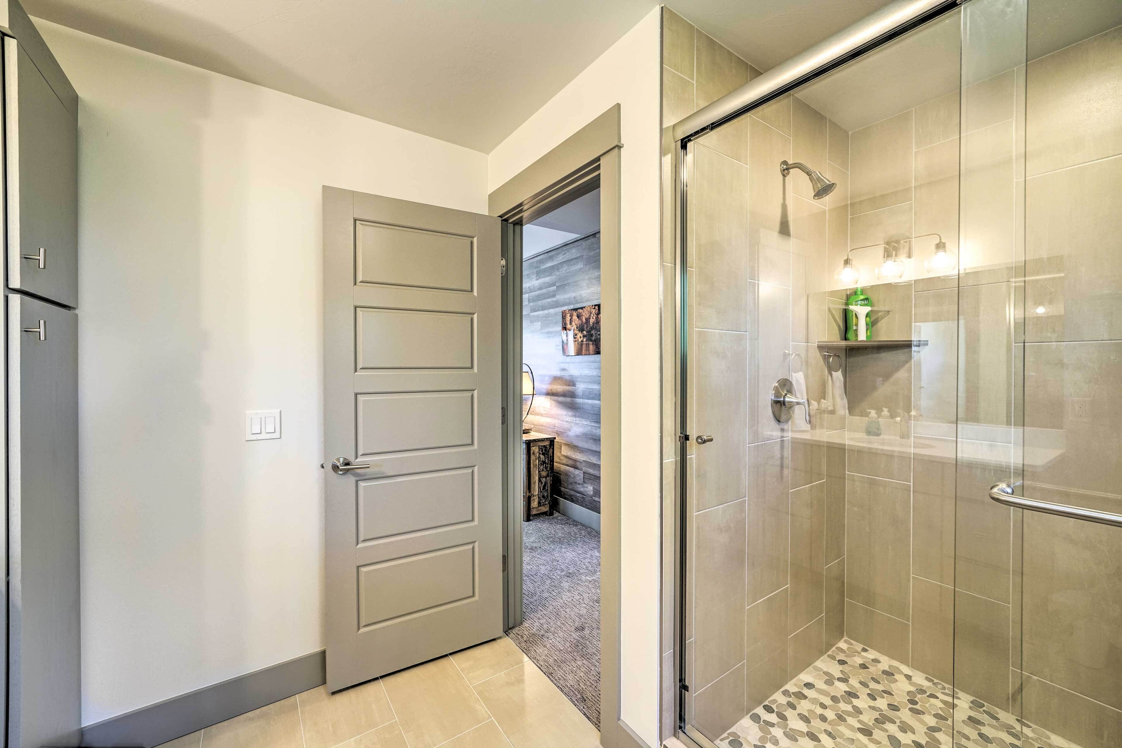 A modern bathroom with a shower, a toilet, and a sink.