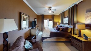 Habitación de hotel con cama, escritorio, televisor, ventilador de techo y vista al exterior.