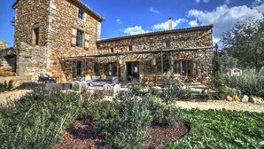 Un edificio de piedra con un patio y un jardín.