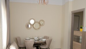Un saló modern amb un sofà modular, una taula de dinar amb cadires, una taula baixa i una obra decorativa a la paret.