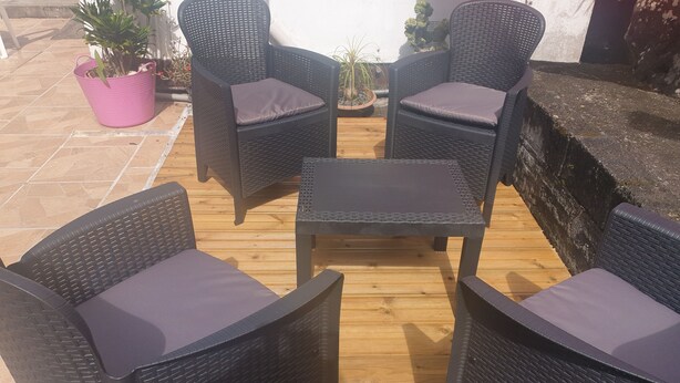 Un espace patio aménagé avec des meubles en osier et des plantes en pot.