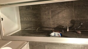 A bathroom with a bathtub, a shower, and a toilet. - Cozy room in a riverside apartment (London)