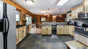 Una cocina moderna con armarios de madera, un refrigerador negro y una isla grande con asientos.
