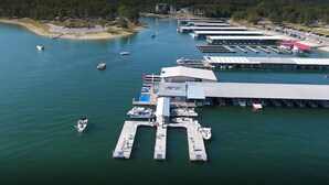 Vista aérea de un puerto deportivo con varios muelles y barcos.