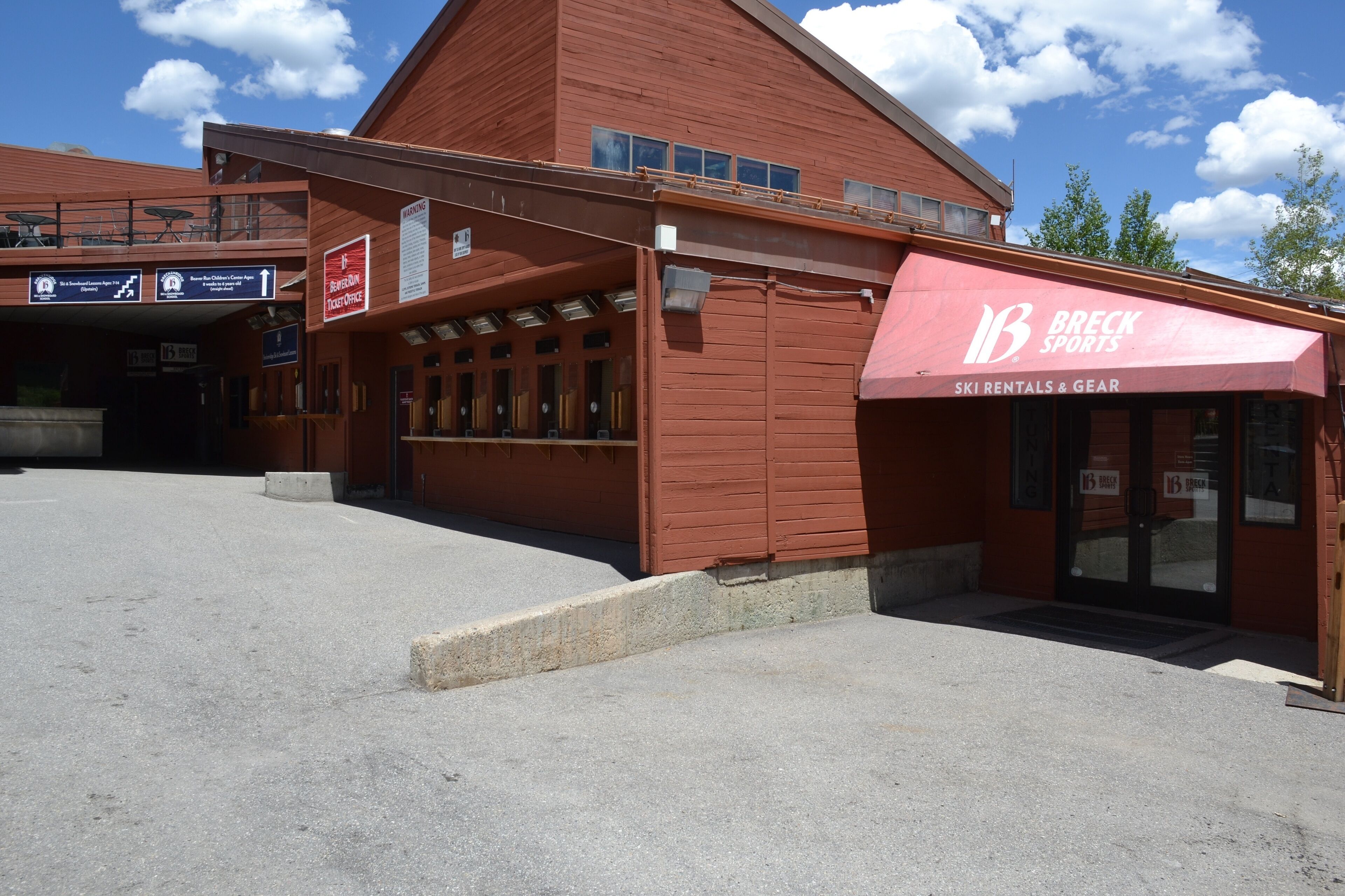 A ski rental and gear shop with a red awning and a ticket office sign.