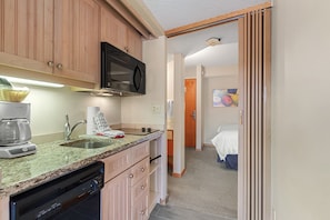 Enjoy a compact room with a kitchenette, single bed, and bathroom featuring a shower.
