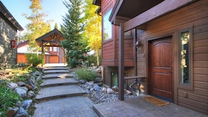 A wooden building with a stone pathway leading to a wooden door marked with the number 202. - Stunning Breckenridge Townhome with Private Hot Tub, Garage! (Breckenridge)