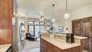 A spacious kitchen with a large island, wooden cabinets, and a built-in oven. - Stunning Breckenridge Townhome with Private Hot Tub, Garage! (Breckenridge)