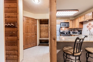 A kitchen with wooden cabinets, a microwave, and a sink.