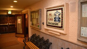 A hallway with a sign for 'Mi Casa Restaurant' and a wooden bench. - Stay Downtown and Quick Walk to Quicksilver Lift! (Breckenridge)