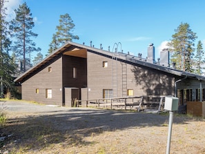A wooden cabin with a sloped roof, a covered porch, and a chimney.