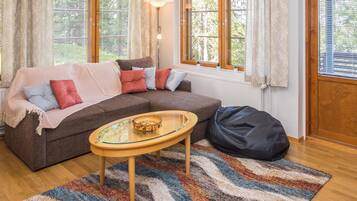 A cozy living room with a sofa, a glass-top coffee table, and a rug.