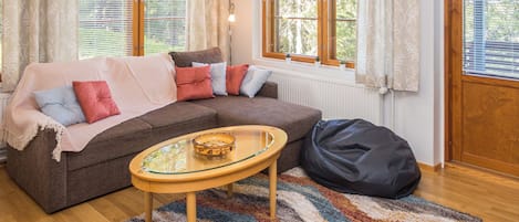 A cozy living room with a sofa, a glass-top coffee table, and a rug.