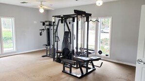 A home gym with a squat rack, bench press, and various weight machines. - 🏡Comfy & Convenient 1BR Apartment Near Oaks Mall & Medical Center Fast WIFI (Gainesville)