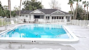 A rectangular pool with a 8 ft. depth marker, surrounded by a white fence, with a house in the background. - 🏡Comfy & Convenient 1BR Apartment Near Oaks Mall & Medical Center Fast WIFI (Gainesville)