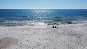 A beach with a sandy shore and a clear view of the ocean.