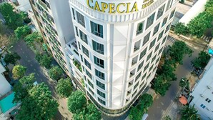 Un hotel de varios pisos con una fachada curva y el nombre 'Capecia Hotel' visible en grande.