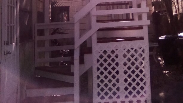 A white metal staircase leading to a building entrance. - Private apartment in historic house (St. Augustine)