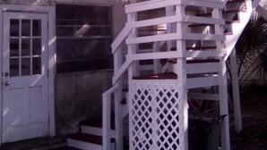 A white metal staircase attached to a building with a door and windows. - Private apartment in historic house (St. Augustine)