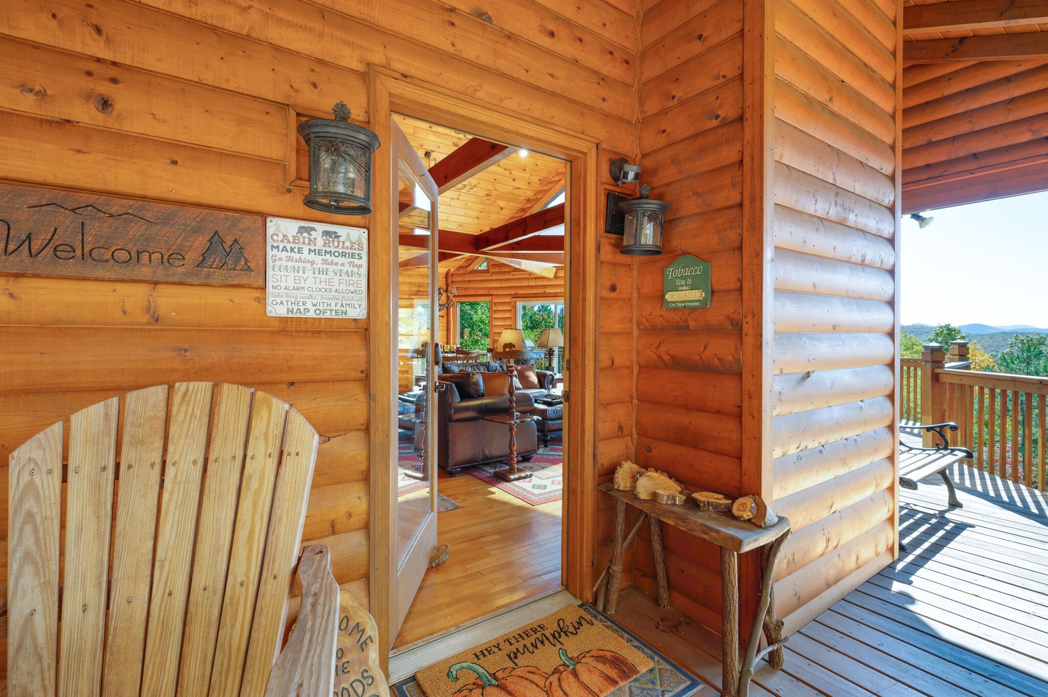 A wooden cabin with a 'Welcome' sign, a 'Cabin Rule' sign, a 'Tobacco' sign, and a 'Hey There Pumpkin' mat.