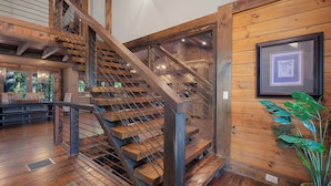Un escalier en bois avec des rampes en métal menant à un niveau supérieur.