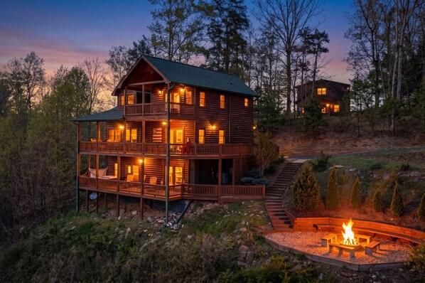 A multi-story log cabin with a balcony, a fire pit, and a view of the surrounding forest. - Amazing View - Mineral Bluff (Mineral Bluff)