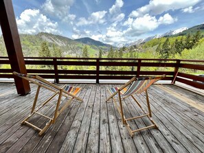 A wooden deck with two wooden chairs and a hammock, overlooking a mountainous landscape with a clear sky. - Ski-in/ski-out apartment, 2 bedrooms, terrace and covered parking - La Clusaz (La Clusaz)