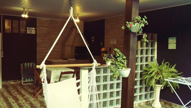 Una habitación acogedora con una hamaca, plantas en macetas y suelo de madera.